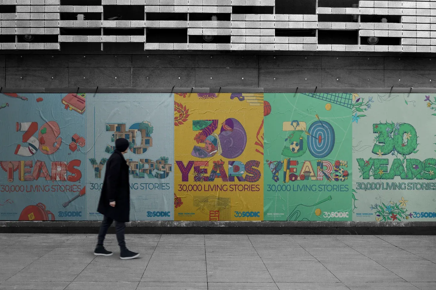 A pedestrian passing a long row of SODIC anniversary posters on an urban wall