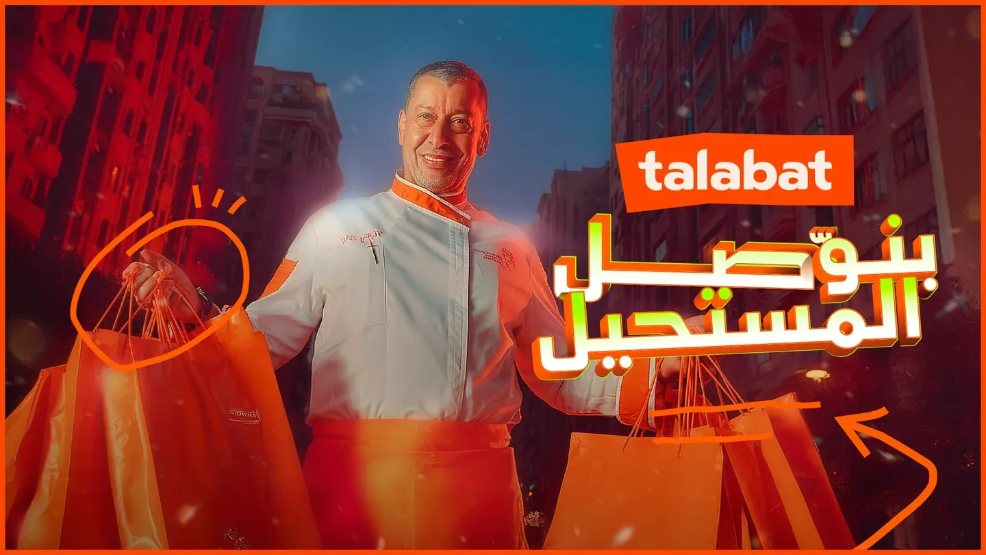 Talabat artwork with a smiling man holding orange shopping bags in a warmly lit street