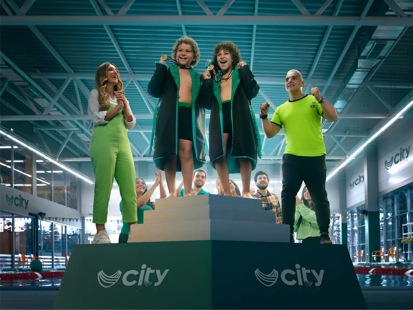 CityClub podium artwork with three women celebrating inside a bright sports hall