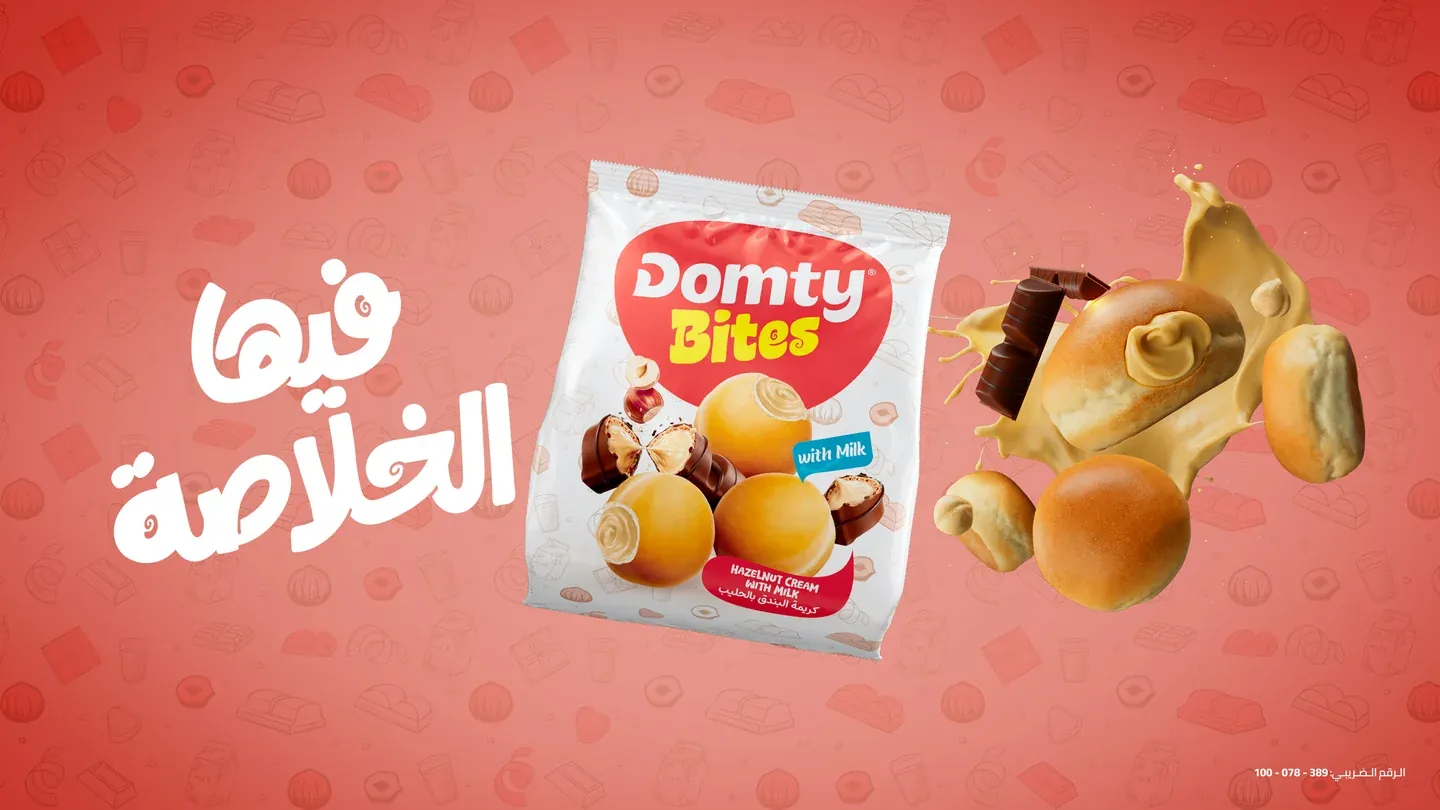 Domty Bites hazelnut pack with floating nuts, cream and round snacks on coral