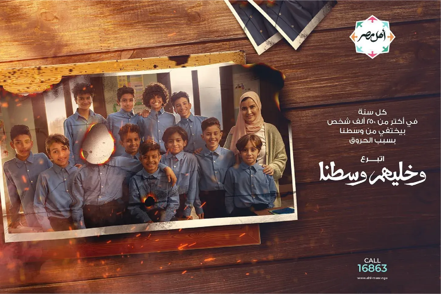 Ahl Masr campaign showing a school class photograph with a burned opening, wooden frames and Arabic lettering